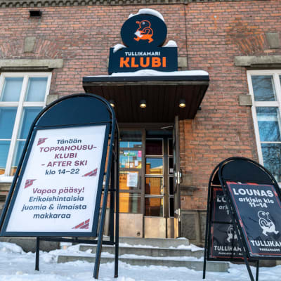 Tampereen Tullikamarin Klubin julkisivu ja Toppahousuklubi -tapahtumasta kertova kyltti 