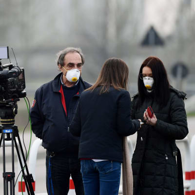 Reportrar med ansiktsmask i den lilla staden Casalpusterlengo, sydost om Milano 23.2.2020 