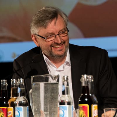 Sergei Loznitsa nauraa kysymykselle paneelikeskustelussa.