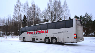 Buss som körs av bolaget Wiik & Ström på en parkering. Vinter.