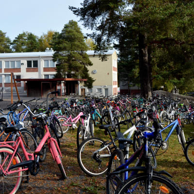 Cyklar parkerade framför skola.