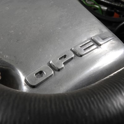 Motordel med bilmärket Opel skrivet på sig.
