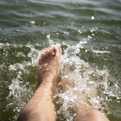 Fötter som plaskar i vatten.