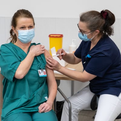En sjukskötare vaccineras med coronavaccinet.