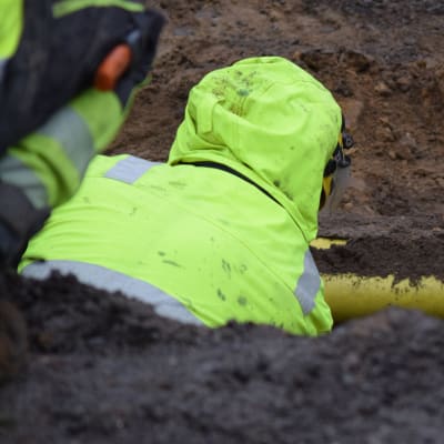 Mies töissä vesijohtojen saneeraustyömaalla