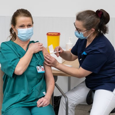 En sjukskötare vaccineras med coronavaccinet.