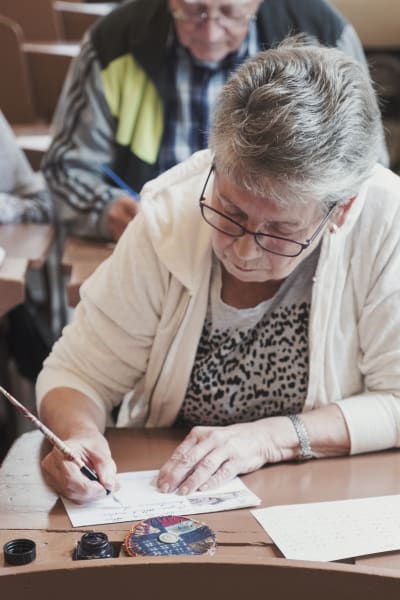 Äldre dam skriver med bläckpenna.