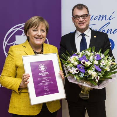Juha Sipilä gav priset till Angela Merkel i Bryssel.