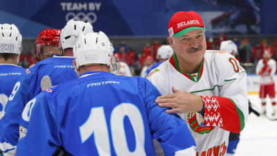 Vitrysslands president Aleksandr Lukasjenko skakar hand  med motståndare efter en ishockeymatch
