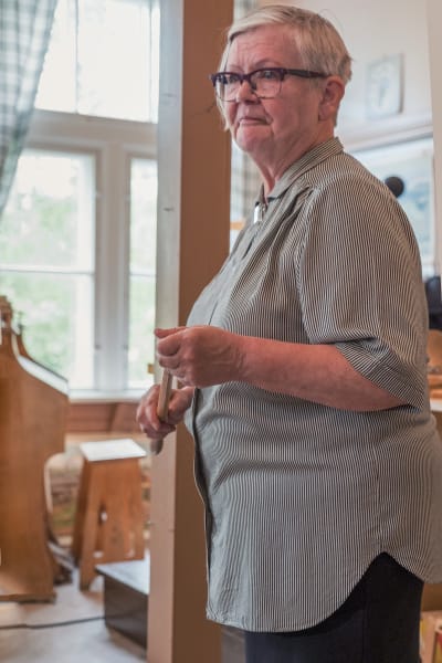 Skolmuseets lärare Päivi Hakoma håller en pekpinne i sina händer.
