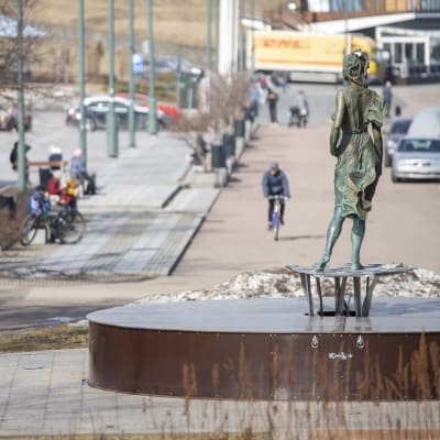 Ihmisiä ulkoilemassa Lappeenrannan satamassa ja katselemassa patsasta.