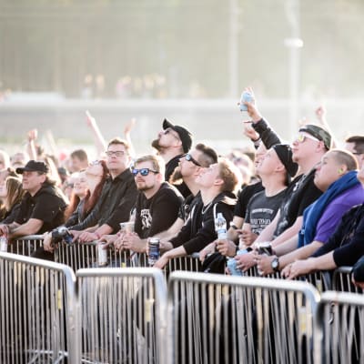 Publik från Rock Fest som pekar mot himlen
