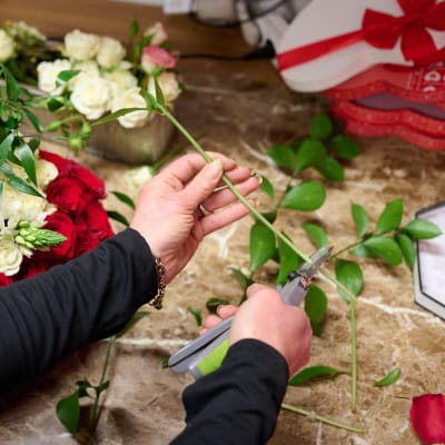 En florist klipper och fixar rosor.