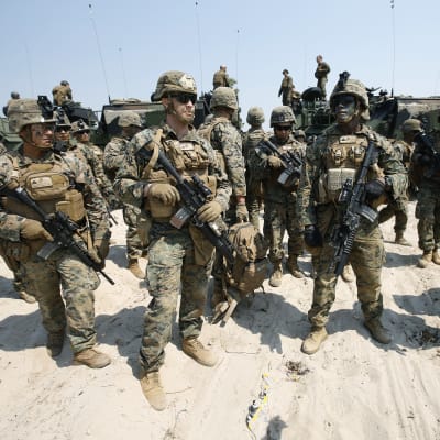 Amerikanska marinsoldater uppställda framför pansarfordon.
