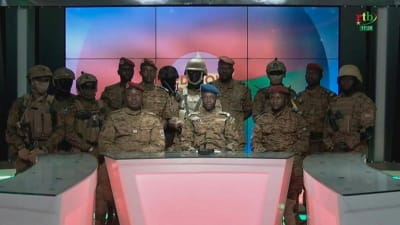 Skärmdump från militärens tv- och radiosända tal den 24 januari 2022. En talesperson för militärjuntan, Sidsore Kader Ouedraogo, sitter i mitten omgiven av ett flertal soldater.