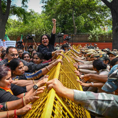 Kvinnor som stöder det indiska regeringspartiet BJP protesterar våldsamt mot ett staket polisen i Delhi har satt upp.