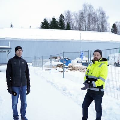 två män i snön framför bollhall