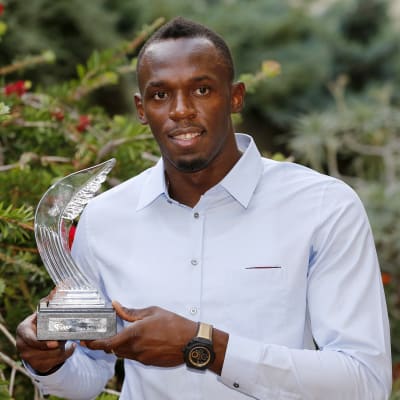 Usain Bolt håller i en pokal