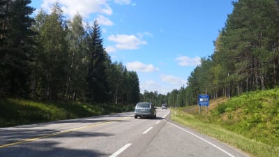 En bil susar fram på landsvägen.