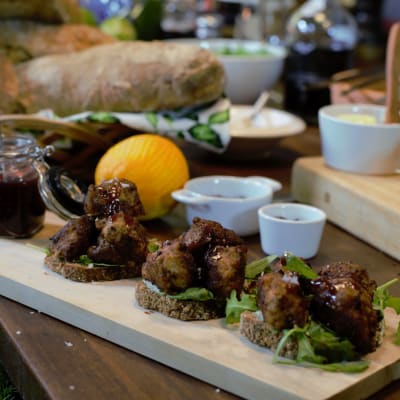 Portioner med kalkonköttbullar på brödskivor med cumberlandsås på en skärbräda