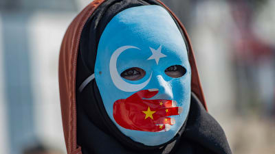 En maskförsedd demonstrant visar sitt stöd för uigurerna under en protestaktion utanför Kinas konsulat i Istanbul