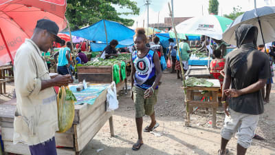 En kvinna med Bougainflagga på skjortan på torget i Bougainvilles huvudstad Buka