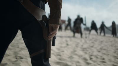 Närbild på Han Solos (Alden Ehrenreich) hand just innan han skall dra sitt vapen.