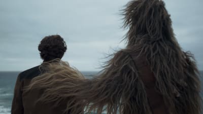 Han Solo (Alden Ehrenreich) och Chewbacca (Joonas Suotamo) står med ryggen mot kameran och ser ut över havet, Chewbacca har lagt sin hand på Hans axel.