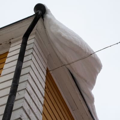 Paljon lunta puutalon katolla Porvoossa.