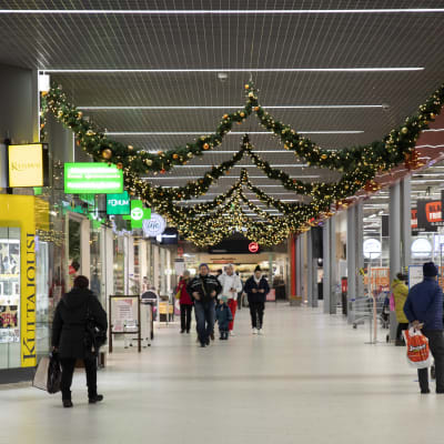 Kouvolan Kauppakeskus Veturin joulukoristeilla koristeltu käytävä sekä käveleviä ihmisiä.