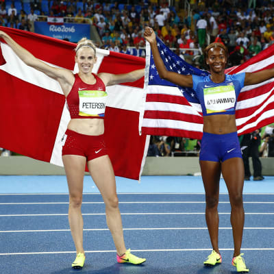 En danska och en amerikanska håller upp sina respektive länders flaggor efter häcklopp.