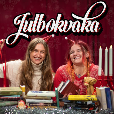 Två kvinnor som sitter framför ett julbord av böcker.