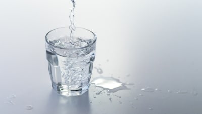 vatten som hälls i ett glas