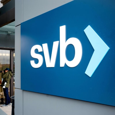 SVB-pankin logo on pankin pääkonttorin aulan seinällä, valkoista tekstiä sinisellä pohjalla. Aulassa näkyy valokuvaaja.