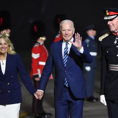 Joe Biden håller sin fru Jills hand och vinkar till fotografer.