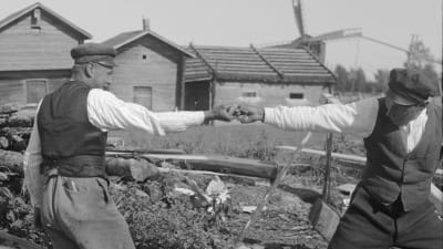 Två män leker leken "dra fingerkrok". Bilden är tagen 1930 i Korsnäs kyrkby,