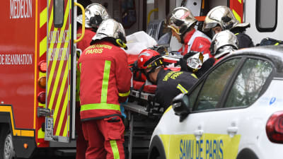 Räddningspersonal lyfter en en sjukhusbår i ambulansen i Paris.