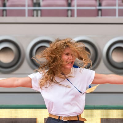 Kvinna står framför luftkoniditoneringsapparat på stadion i Doha.