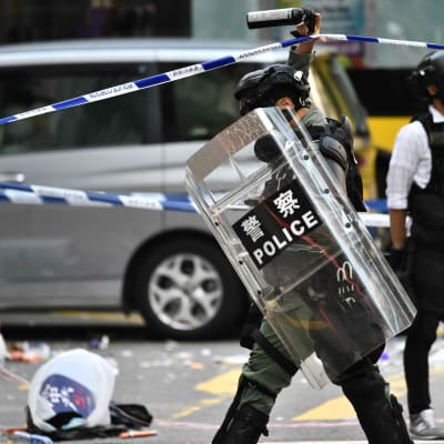 Poliser vid avspärrningarna runt den plats där en demonstrant sköts i Hongkong på måndag morgon. 