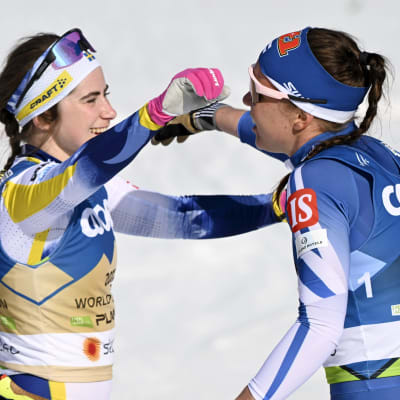 Hiihtäjät Ebba Andersson ja Kerttu Niskanen halaavat.