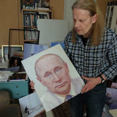 Kaj Stenvall esittelee maalaustaan valkotakkisesta Putinista.