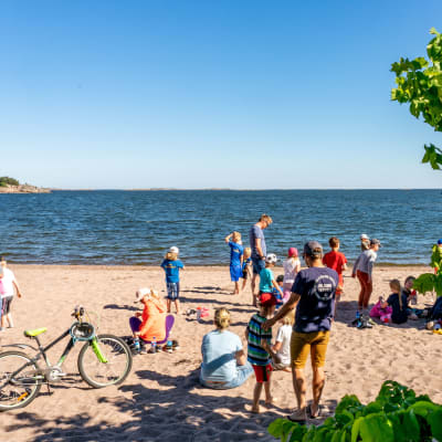 Människor på en blåsig, men solig och varm badstrand i Hangö, Plagen