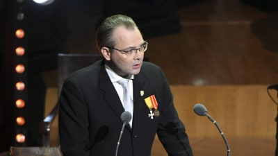 jussi Niinistö håller tal i Finlandiahuset framför två mikrofoner.