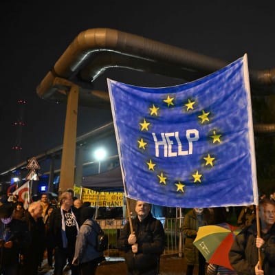 Demonstranter håller i en banderoll med EU-flaggan med texten "Hjälp" under en demonstration för oberoende nyheter i Ungern. 