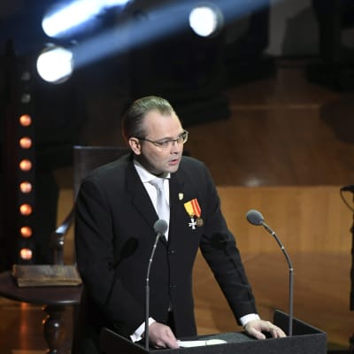jussi Niinistö håller tal i Finlandiahuset framför två mikrofoner.