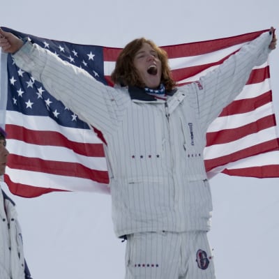 Shaun White firar sitt första OS-guld, det han tog i Turin 2006. Han är draperad i den amerikanska flaggan.