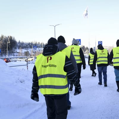 Pappersförbundetgs strejkvakter med gula västar i vintermarsch.