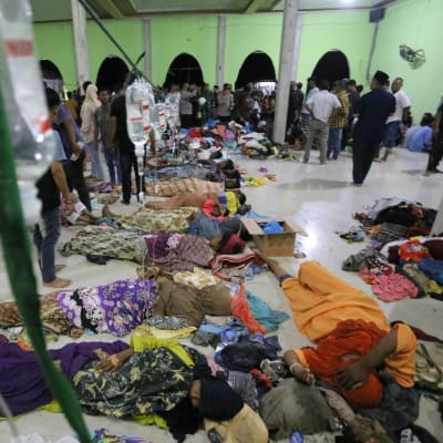 Flyktingar på ett golv får vård.