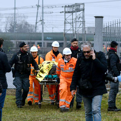 Räddningspersonal evakuerar skadade från olycksplatsen utanför Milano.