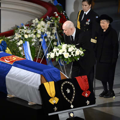 Eeva ja Marko Ahtisaari laskevat kukkalaitteen.